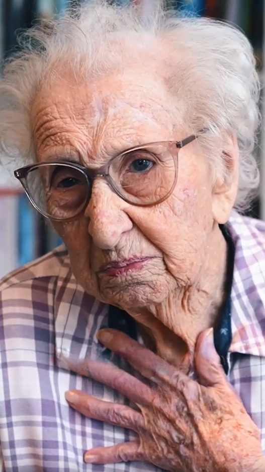 Senior woman with large glasses and hand on chest